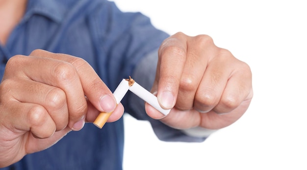 Hombre sujetando cigarrillo roto en manos aislado sobre fondo blanco.