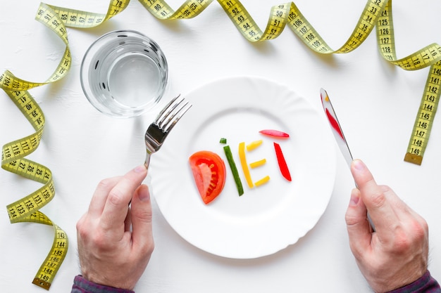 Hombre sujetando los cubiertos en un plato con la palabra