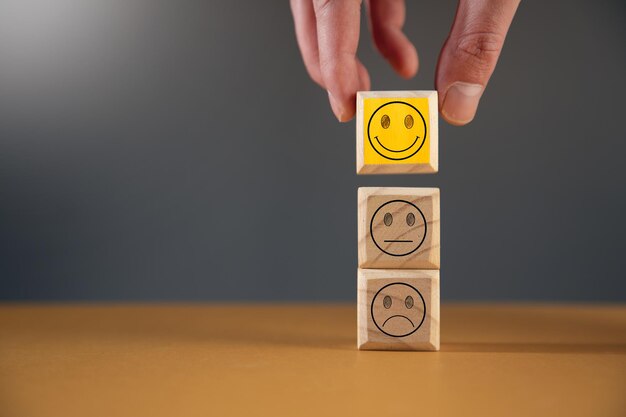 Hombre sujetando cubos de madera con cara de emociones