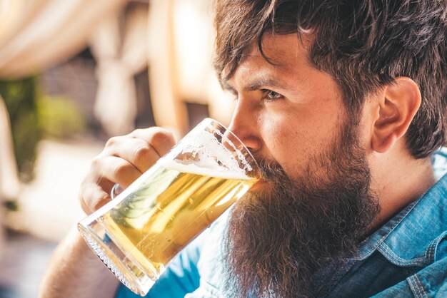 Hombre sujetando jarra de cerveza Hipster barbudo sostiene cerveza embotellada artesanal Hipster relajándose en el pub Pubs y bares de cerveza