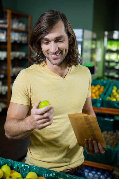 Hombre sujetando limón en supermercado