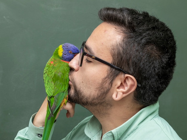 Foto hombre sujetando un loro trichoglossus moluccanus