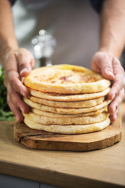 Hombre sujetando pan de queso khachapuri, comida nacional georgiana o caucásica tradicional