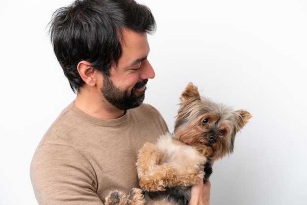 Hombre sujetando un perro aislado sobre fondo blanco.