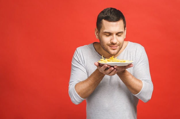 Hombre sujetando el plato con papas fritas