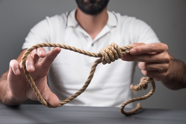 Foto hombre sujetando una soga. concepto de suicidio.