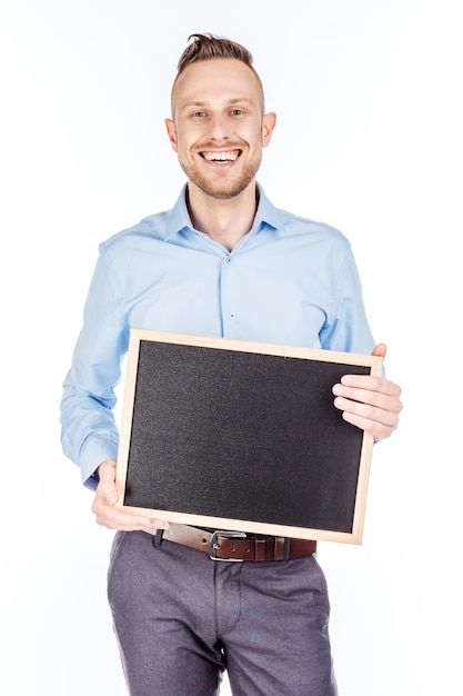 Hombre sujetando tablero negro con espacio para texto sobre fondo blanco.