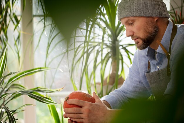 Foto hombre sujetando vegetales cultivados y cultivados en interiores