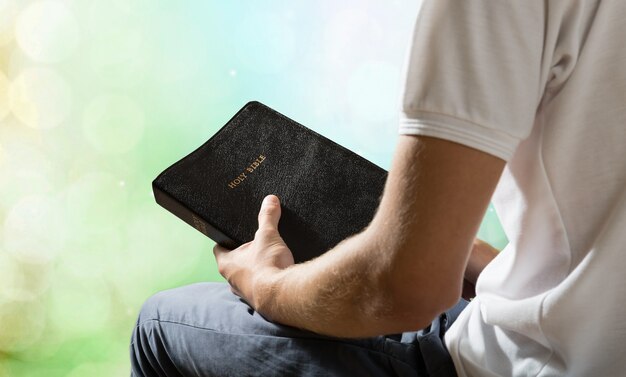 Foto hombre sujetando el viejo libro de la biblia en el fondo