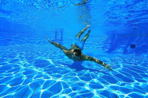 hombre se sumerge en la piscina foto submarina