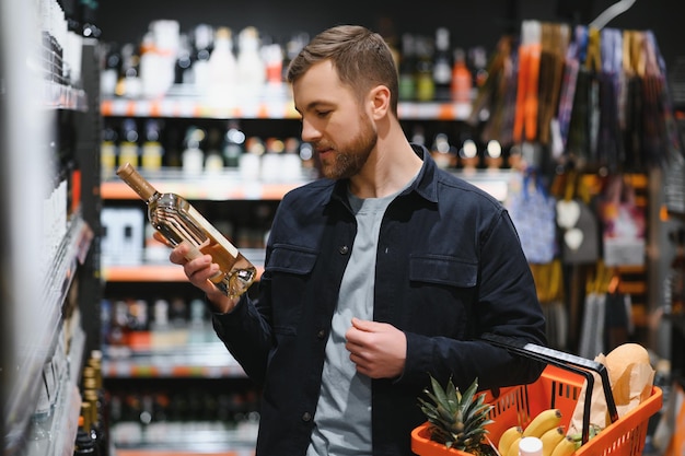 Hombre en un supermercado eligiendo un vino