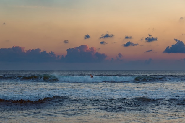 Hombre de surf al atardecer en Seminyak, Bali