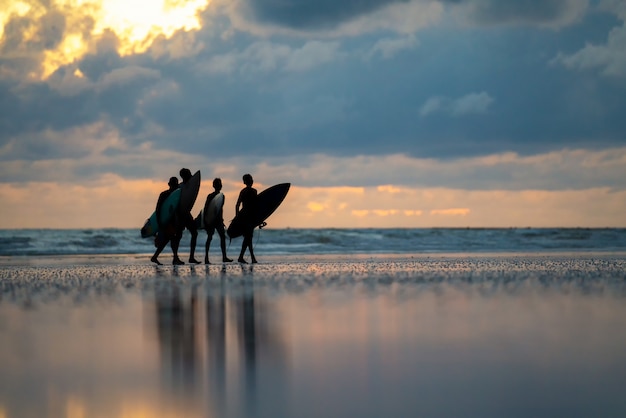 Un hombre con un surf en sus manos en la orilla del mar