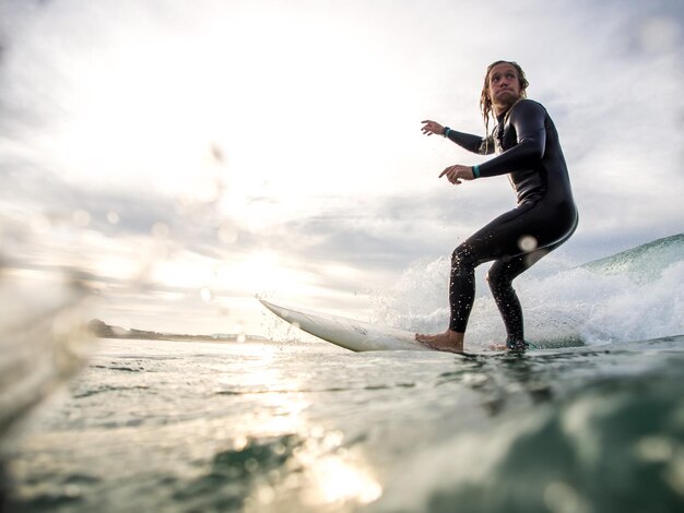 Foto hombre surfeando en el mar contra el cielo