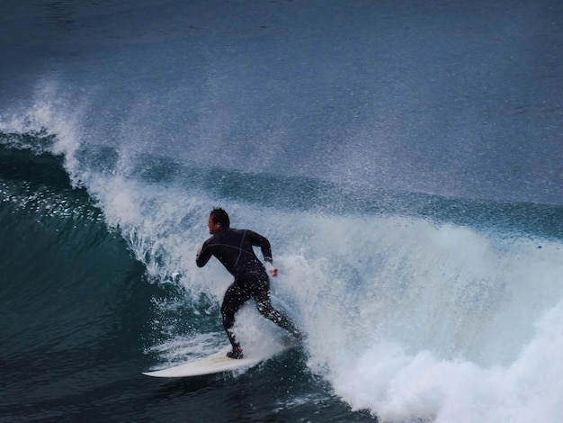 Hombre surfeando en el mar contra el cielo