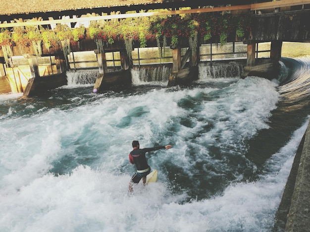 Foto hombre surfeando en el mar