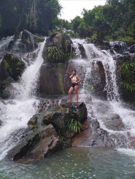 Foto hombre surfeando en la roca en la cascada