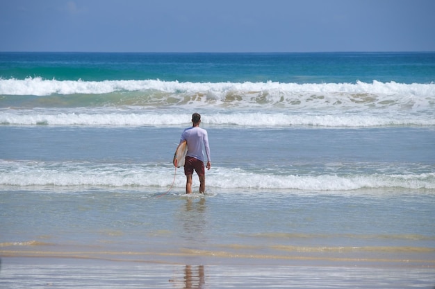 Foto el hombre va a surfear al océano.