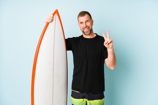 Hombre surfen aislado en la pared azul que muestra el número dos con los dedos.