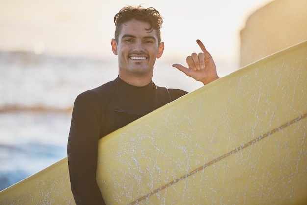 Foto hombre surfista y shaka en retrato de playa con sonrisa de tabla de surf o colgar letrero suelto en el sol al aire libre océano feliz y chico con colgar diez manos puesta de sol de verano o surfear en el mar para hacer ejercicio de deportes acuáticos