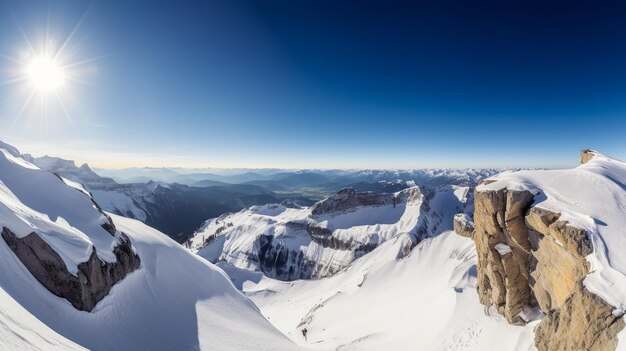 Un hombre en una tabla de snowboard se encuentra en la cima de una montaña nevada.