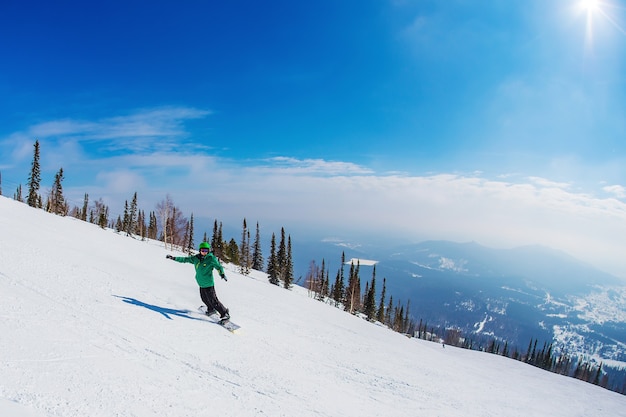 Hombre en una tabla de snowboard en las montañas Sheregesh.