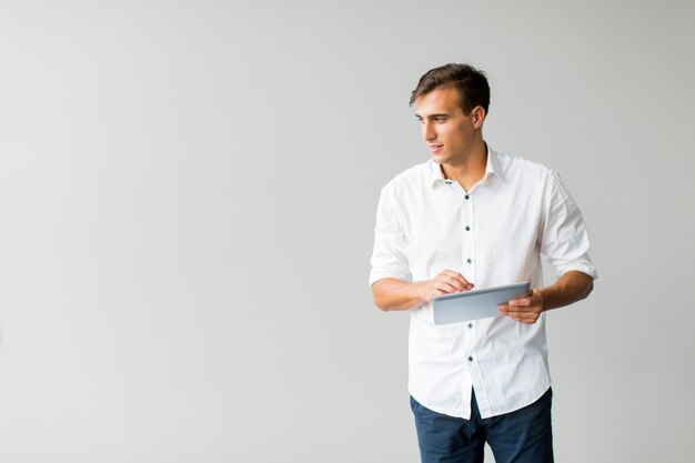 Hombre con tableta junto a la pared