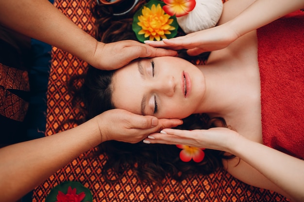 Hombre tailandés haciendo procedimiento de masaje tailandés clásico a mujer joven en la vista superior del salón de belleza spa