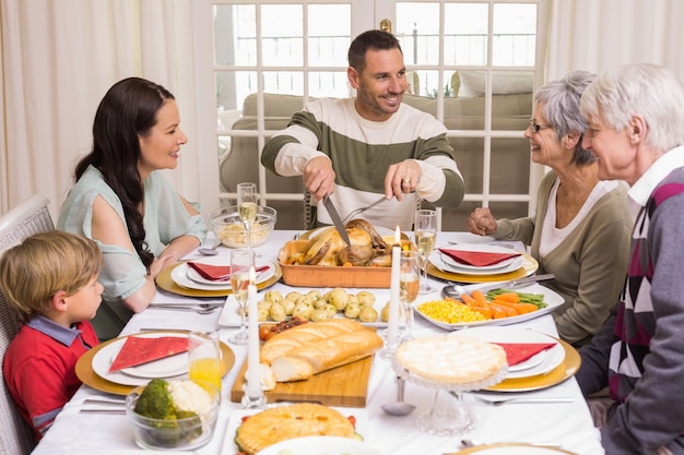 Hombre talla pollo durante la cena de Navidad