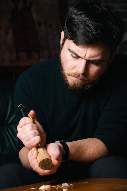 Hombre tallando un bloque de madera con un cuchillo