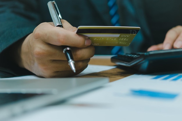 Hombre con tarjeta de crédito con calculadora pago finanzas banca compras comercio en línea concepto de negocio