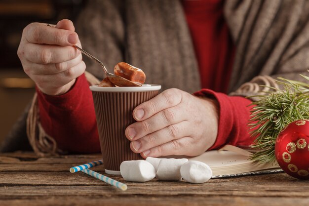 Hombre con taza de chocolate caliente con malvaviscos, bebida navideña de invierno