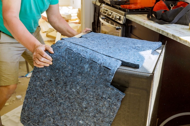 Hombre técnico reparando lavavajillas en cocina