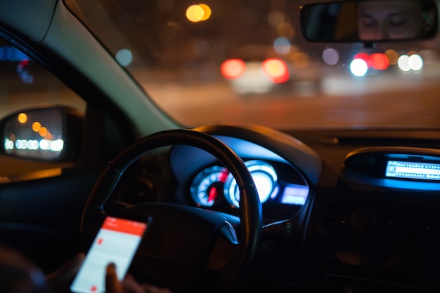 El hombre telefonea en el coche. Por la noche, por la noche