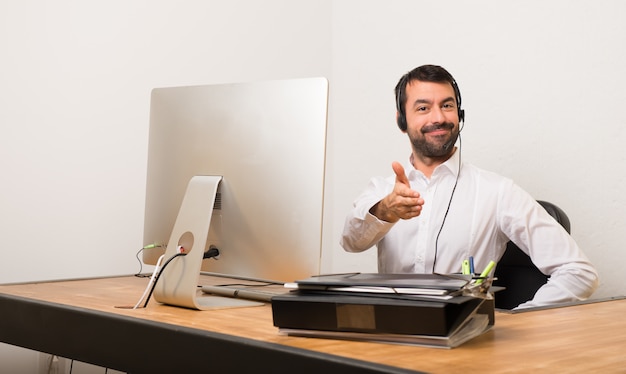 Hombre de telemarketer en un apretón de manos de oficina después de buen trato