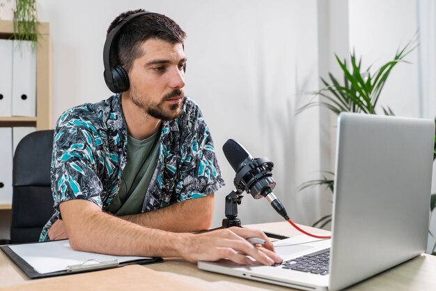 Hombre de telemarketer o podcast trabajando con un portátil y hablando por un auricular en la oficina