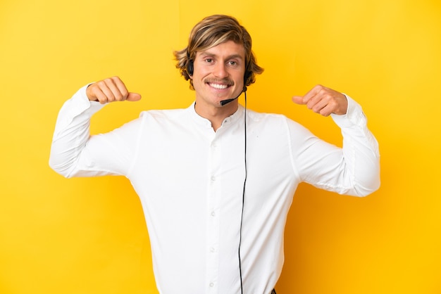 Hombre de telemercadeo que trabaja con un auricular aislado en amarillo haciendo un gesto fuerte