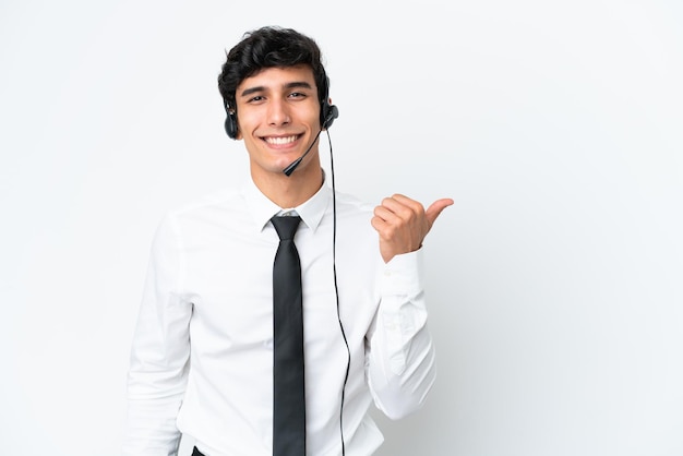 Hombre de telemercadeo que trabaja con un auricular aislado sobre fondo blanco apuntando hacia el lado para presentar un producto