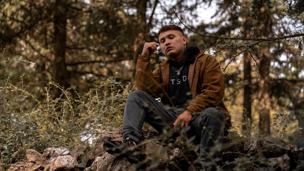 Hombre en la temporada de otoño con chaqueta marrón en el bosque