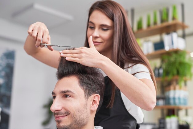 El hombre tiene el corte de cabello en el peluquero