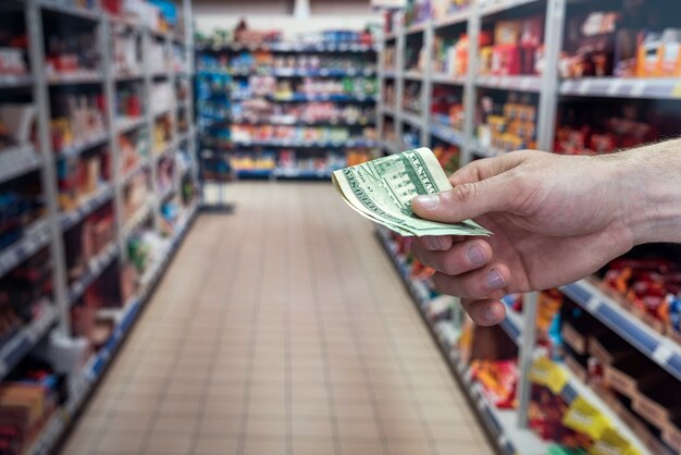 El hombre tiene dólares en el supermercado. concepto de compra