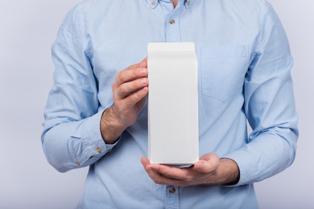 Foto el hombre tiene un gran paquete de leche o jugo. copia espacio, maqueta