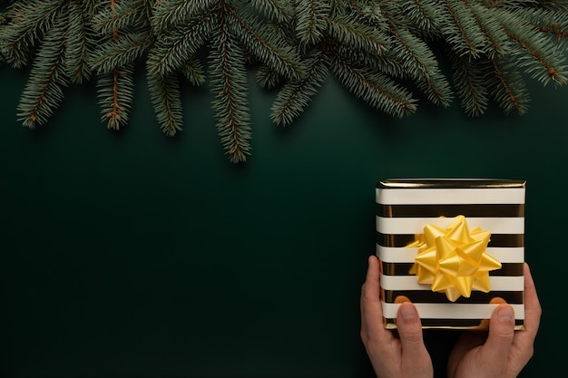 Foto un hombre tiene un regalo de navidad en sus manos