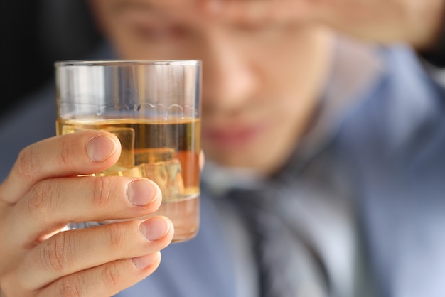 El hombre tiene un vaso de alcohol en sus manos. Lucha contra el concepto de alcoholismo