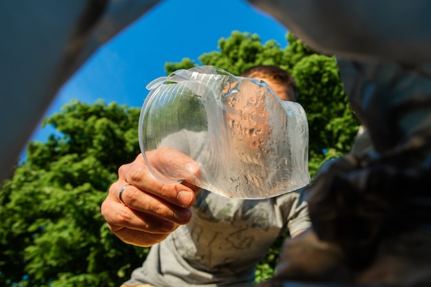 El hombre tira basura en la naturaleza