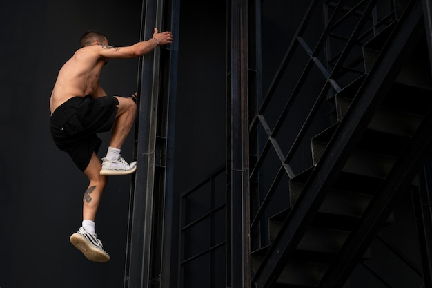 Hombre de tiro completo haciendo entrenamiento de parkour