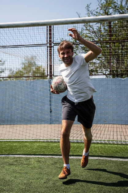 Foto hombre de tiro completo jugando al fútbol