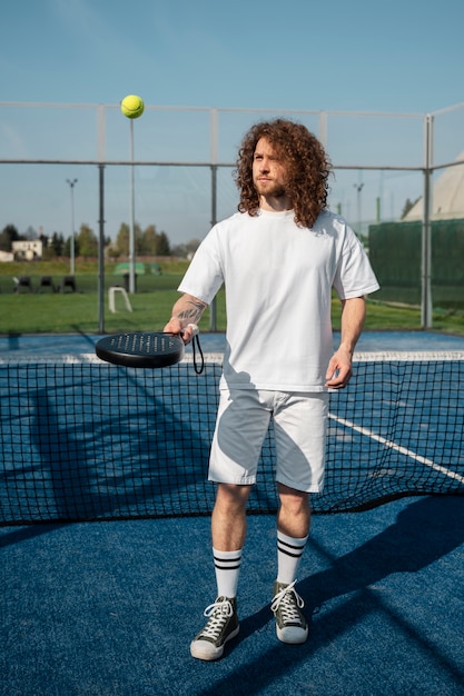 Foto hombre de tiro completo con paleta de tenis