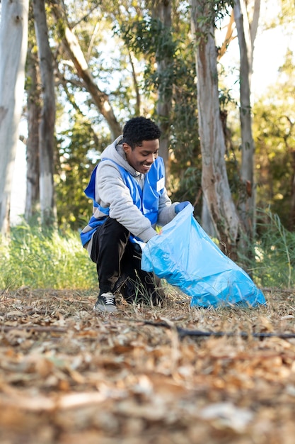 Hombre de tiro completo recogiendo basura