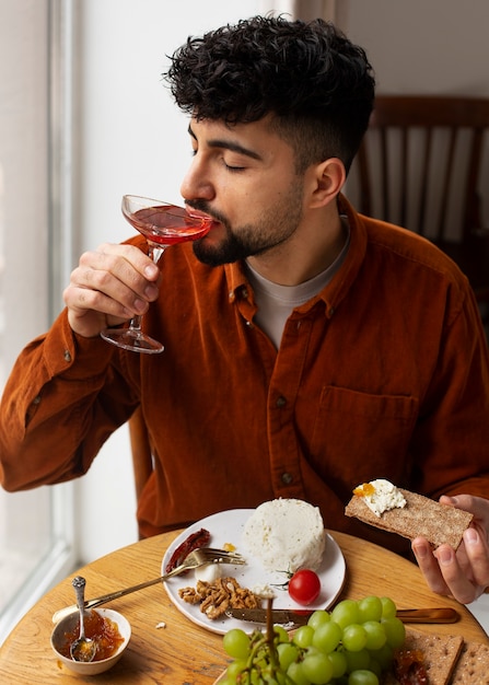 Hombre de tiro medio comiendo queso fresco